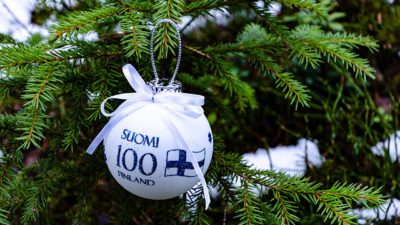 En vit julgranskula där det står Finland 100 på finska och svenska