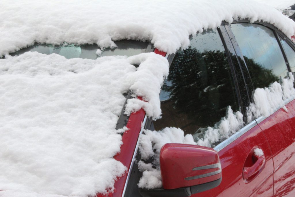 En snötäckt röd bil