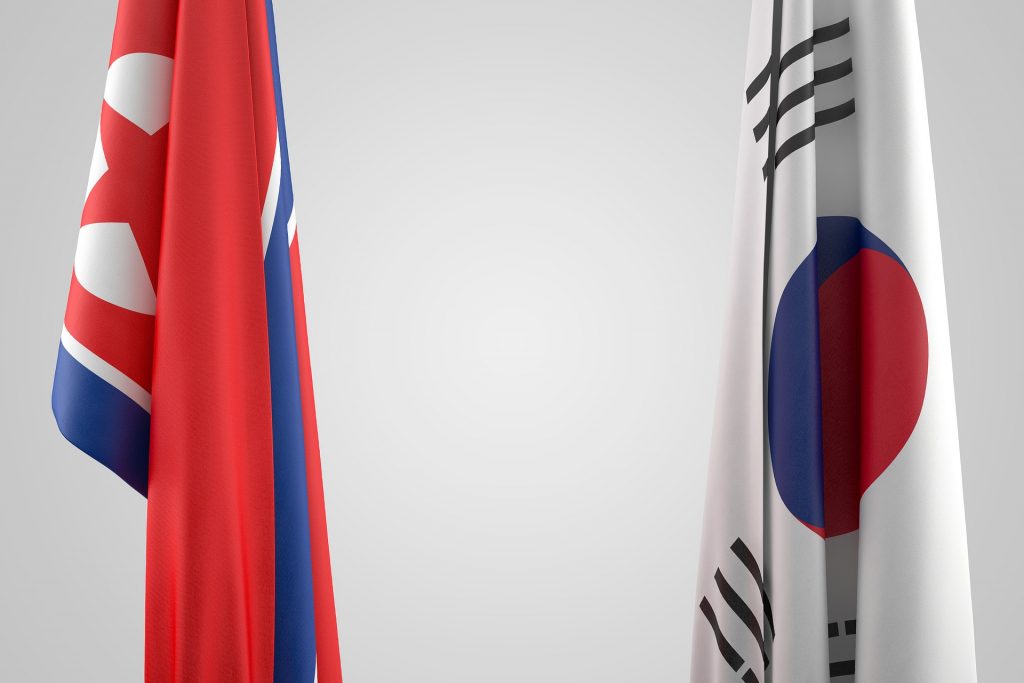 Nordkoreas och Sydkoreas flaggor hänger bredvid varandra.